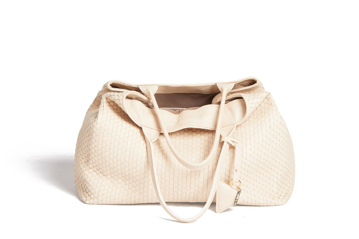 Cream-colored woven leather tote bag with handles and a triangular tag.