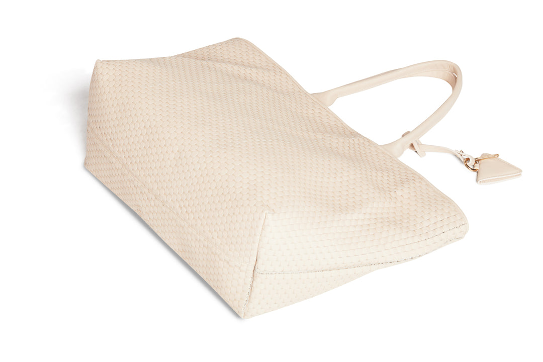 Cream-colored woven leather tote bag with handles and a triangular tag.