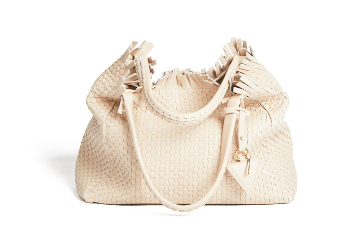 Cream woven handbag with leather straps and tassel detailing.