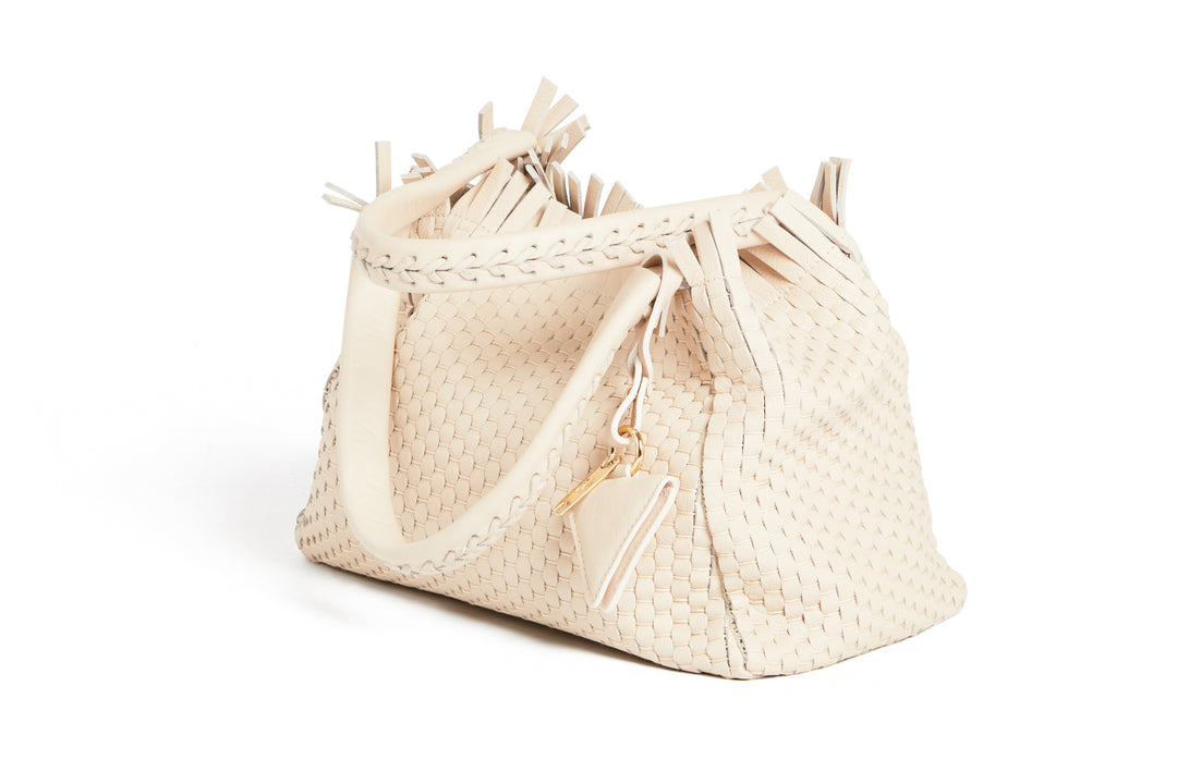 Elegant ivory woven handbag with tassel detail and braided handles.