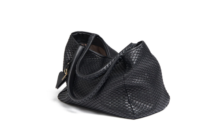 Black woven leather handbag with gold zipper and decorative tassel.