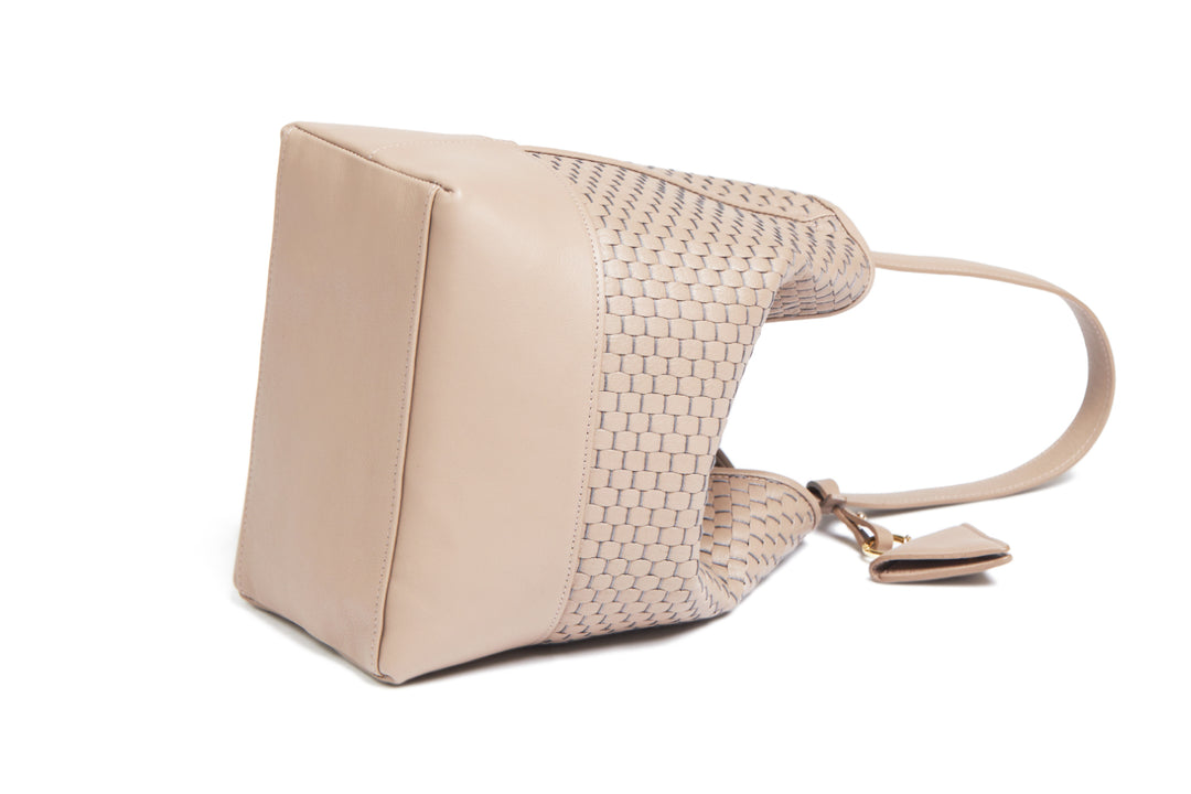 Beige woven leather handbag with adjustable strap on white background.