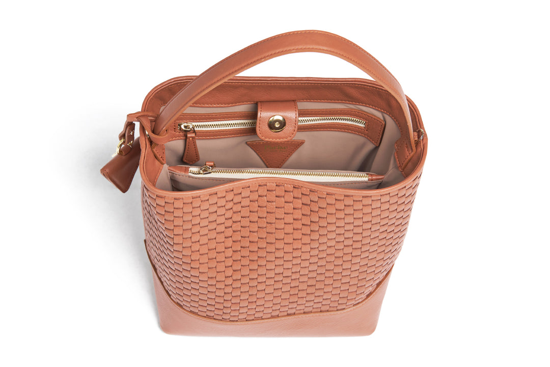 Elegant brown woven leather handbag with adjustable strap and minimalist design.