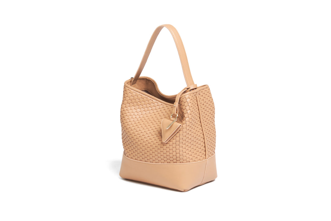 Woven tan leather shoulder bag with adjustable strap and decorative tag.