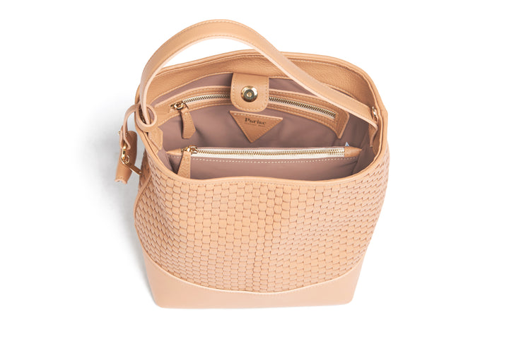 Woven tan leather shoulder bag with adjustable strap and decorative tag.