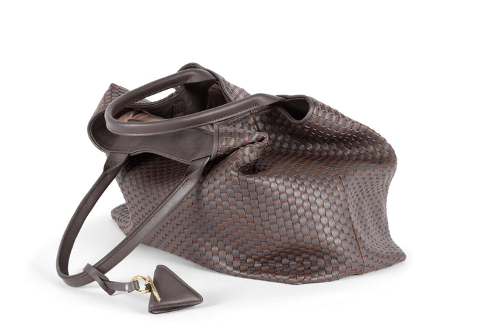 Brown leather woven tote bag with handles and a triangular charm.