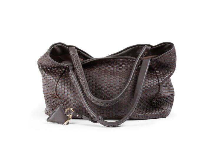 Brown woven leather handbag with a keychain ornament on a white background.