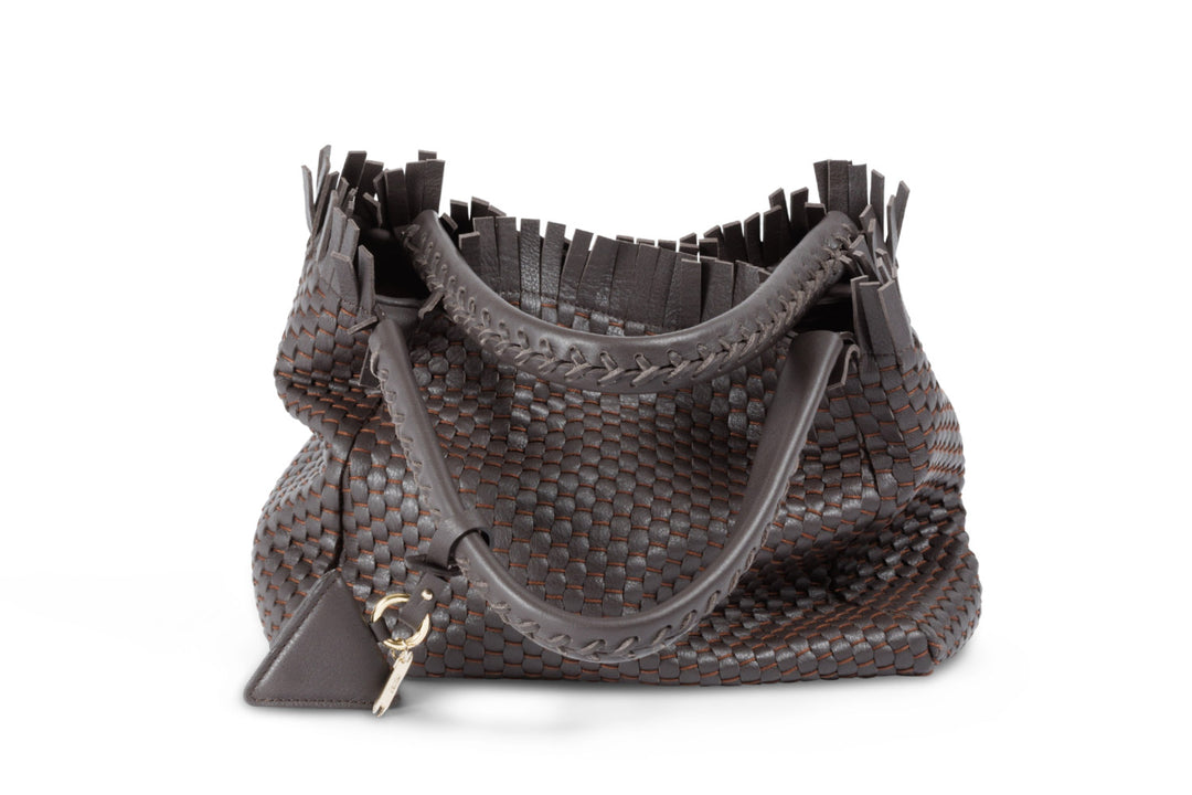 Brown woven leather handbag with tassel accents and dual handles.