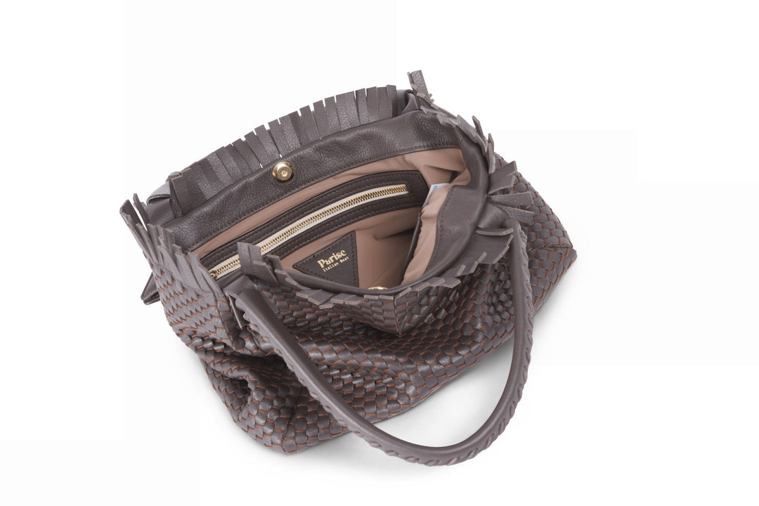 Brown woven leather handbag with tassel accents and dual handles.