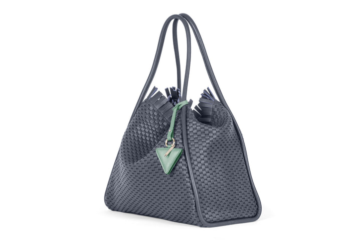 Luxury woven gray handbag with unique fringe details and green accent tag.