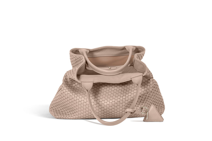 Beige woven tote bag with leather handles and a diamond-shaped keychain accessory.