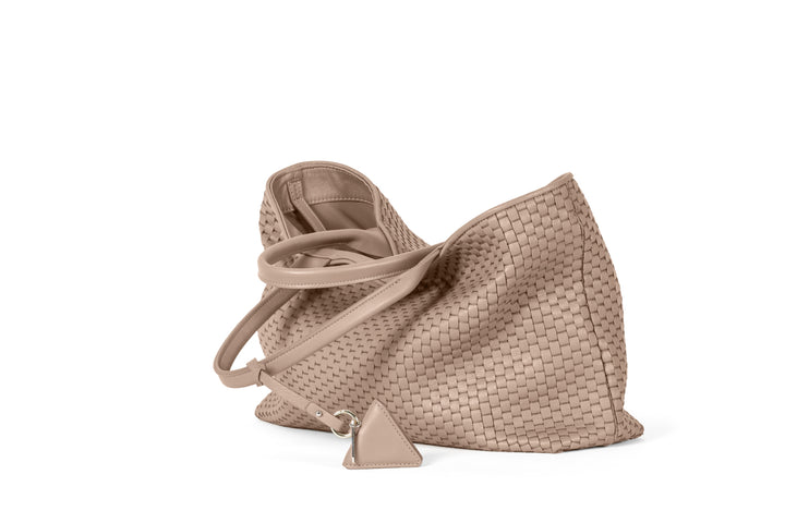 Beige woven tote bag with leather handles and a diamond-shaped keychain accessory.