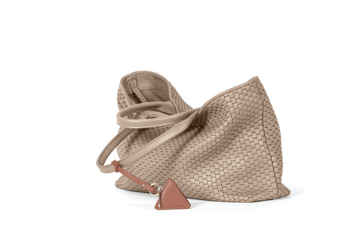 Elegant beige woven tote bag with leather handles and accent tag.