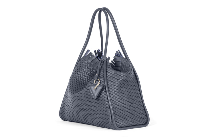 Elegant woven grey handbag with fringe detailing and triangle keychain.