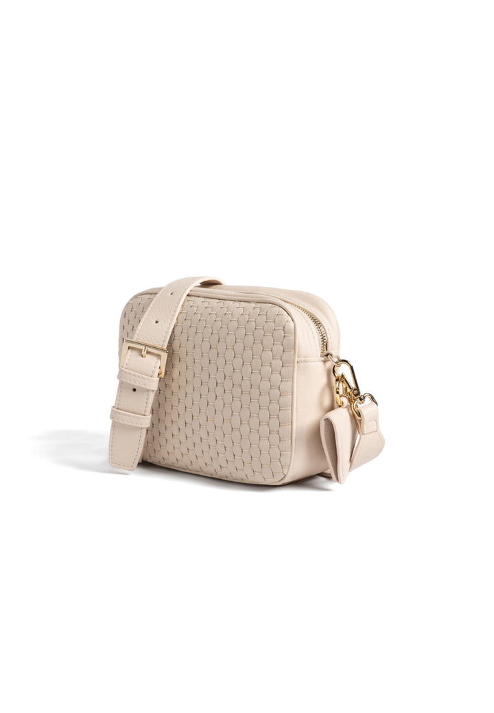 Cream quilted crossbody handbag with adjustable strap.