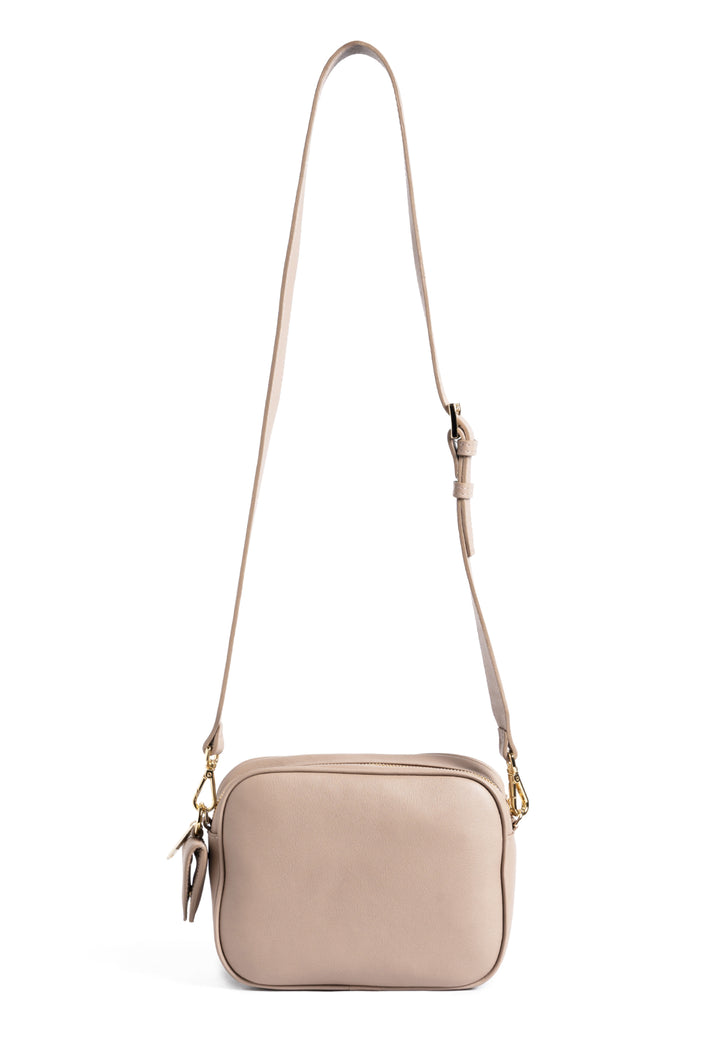 beige quilted crossbody bag with adjustable strap on white background