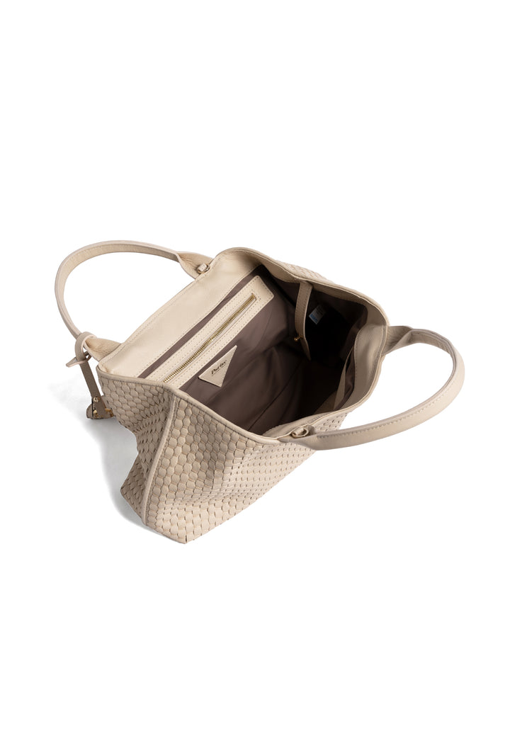 Elegant cream woven leather handbag with gold charm and sturdy handles, isolated on white background.