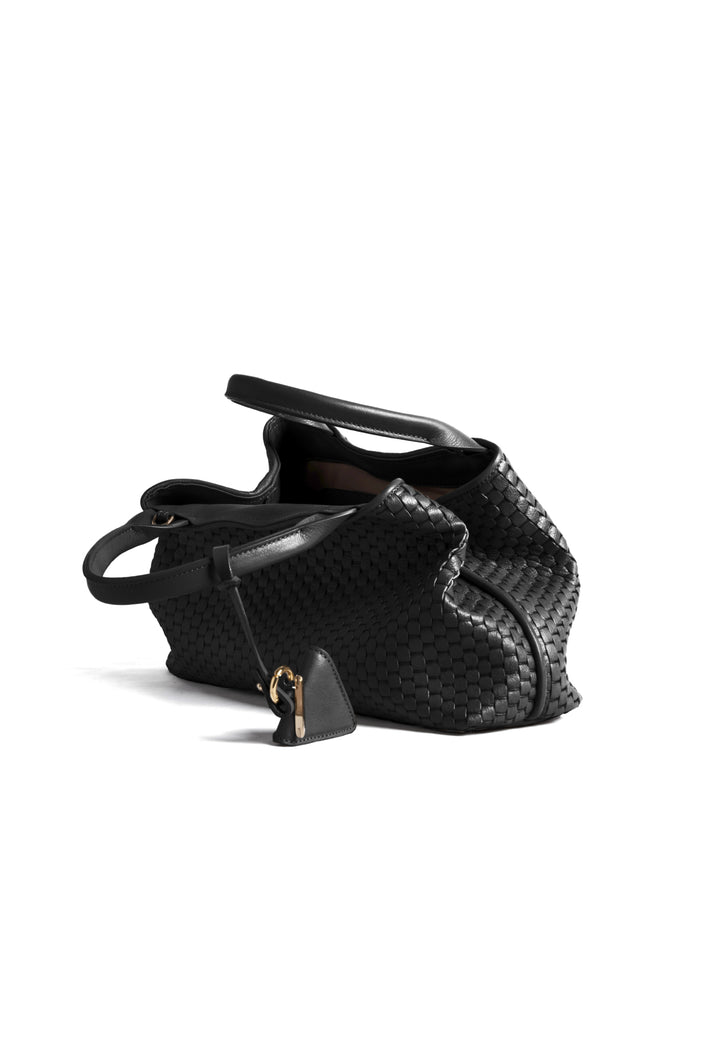 Black woven handbag with leather handles and a small attached accessory.