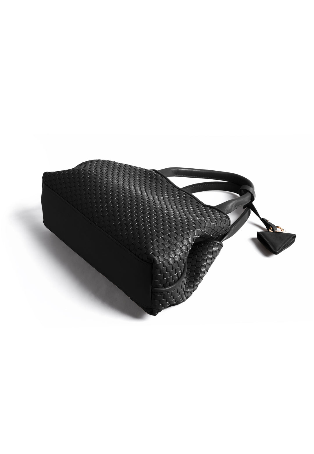 Black woven handbag with leather handles and a small attached accessory.