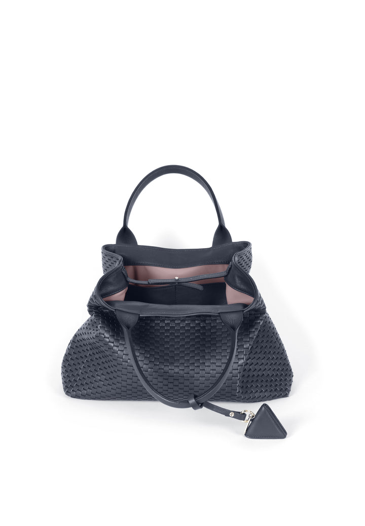 Woven black leather handbag with handles and pendant charm on white background.