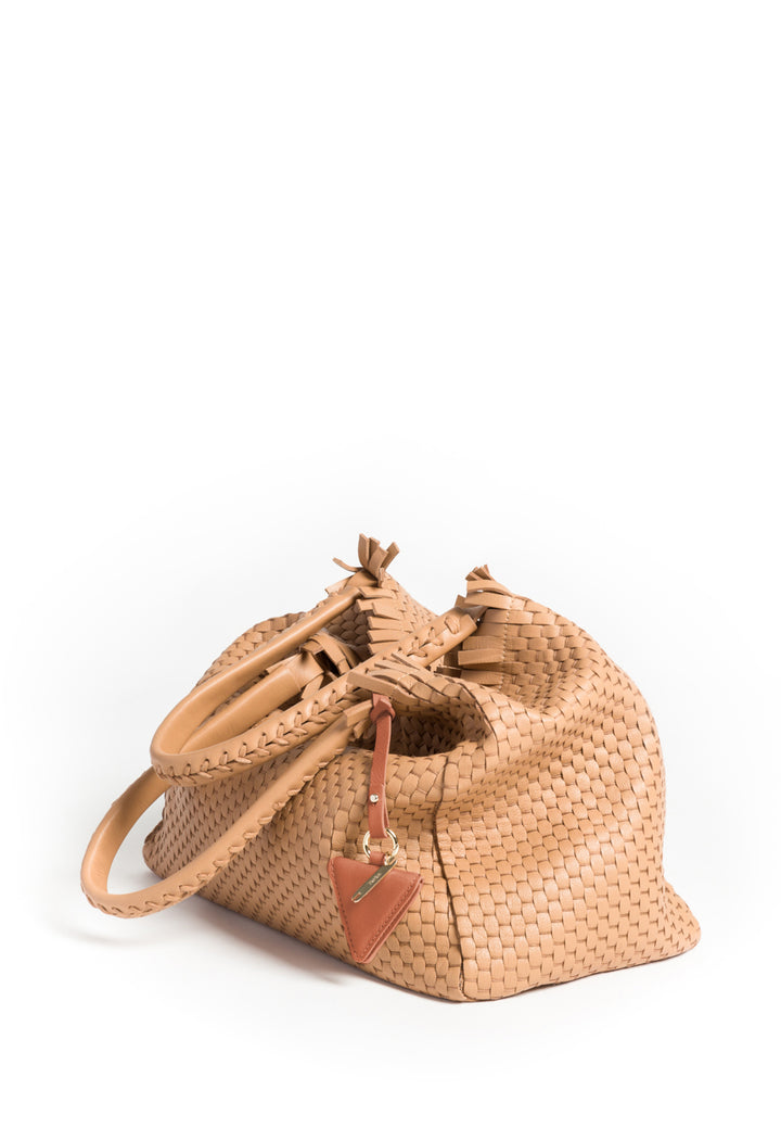 Handcrafted beige woven leather handbag with braided handles and decorative accent tag.