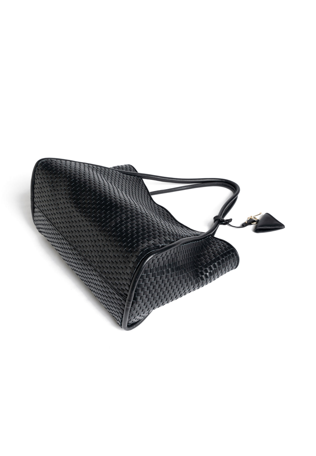 Black woven leather tote bag with handles, featuring a small attached accessory.