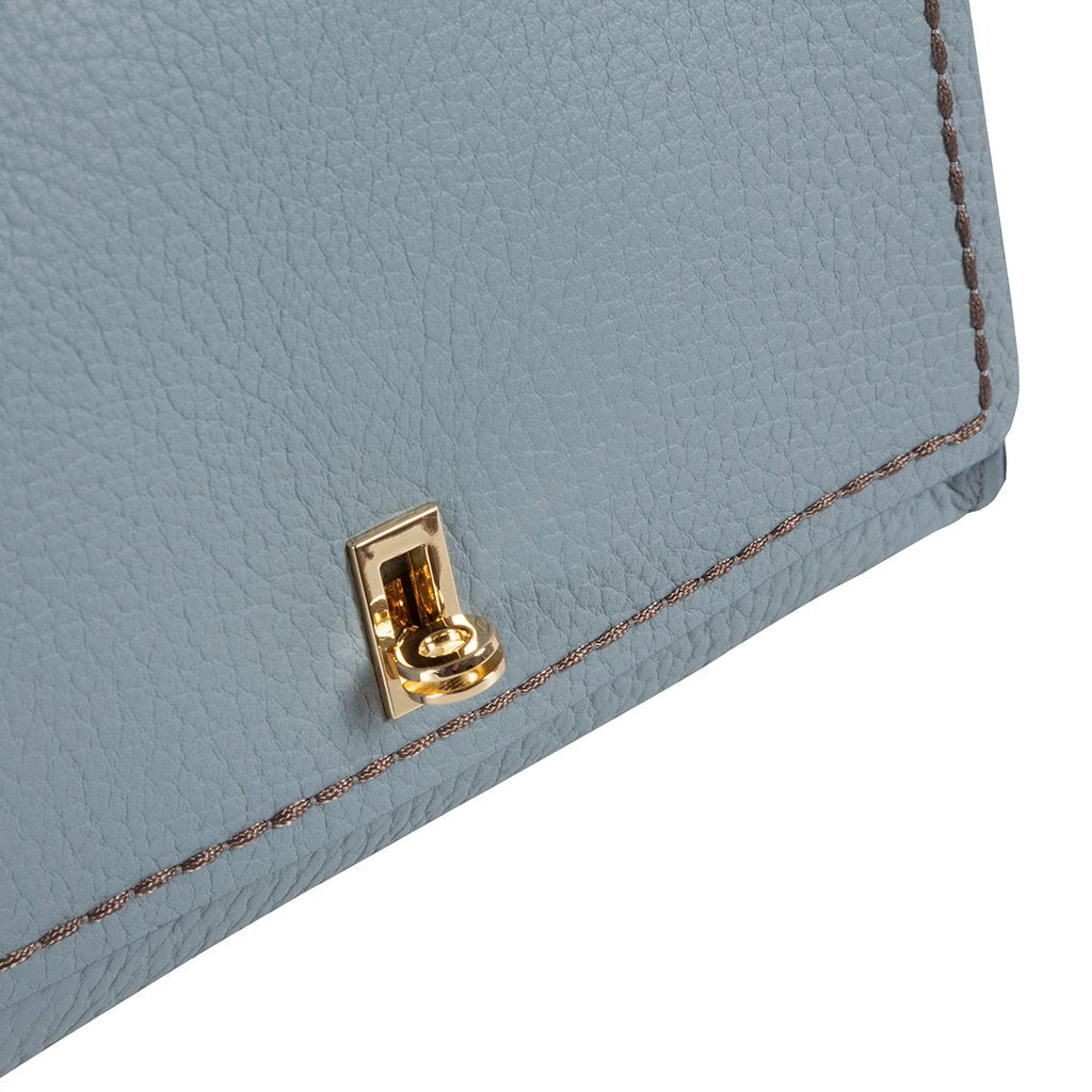 Light blue textured leather handbag corner with gold clasp and stitching details