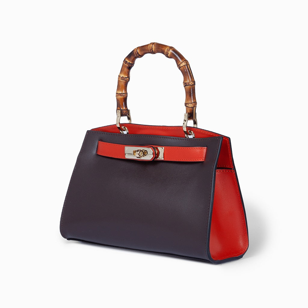 Luxury designer handbag with bamboo handles and red accents