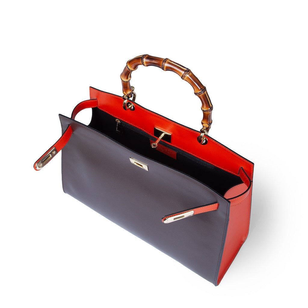 Luxury designer handbag with bamboo handle and red and black leather exterior