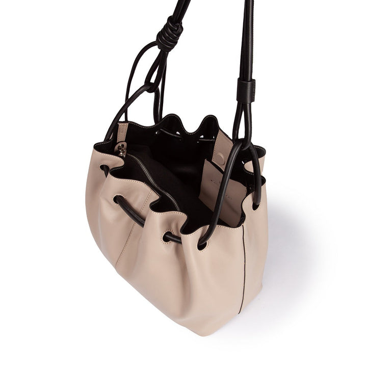 Beige leather drawstring bucket bag with black handles