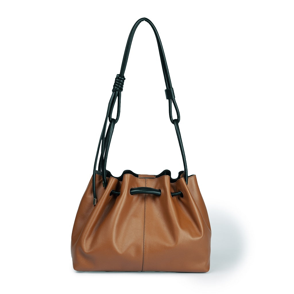 Brown leather drawstring handbag with black handles on white background