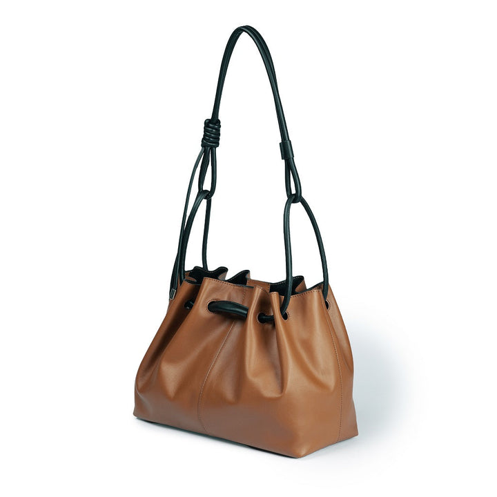 Brown leather handbag with black straps and minimalist design