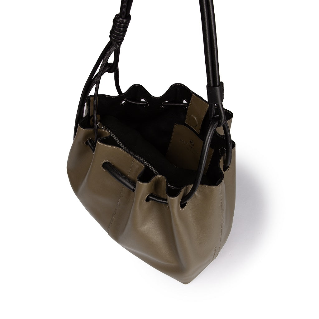 Olive green leather bucket bag with black drawstring and shoulder straps