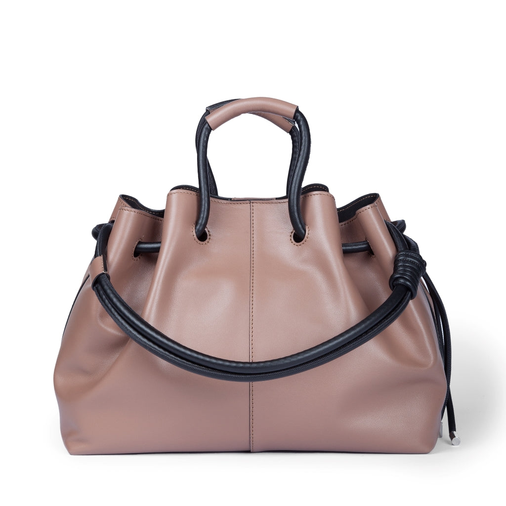 Pink leather handbag with black handles and drawstring closure