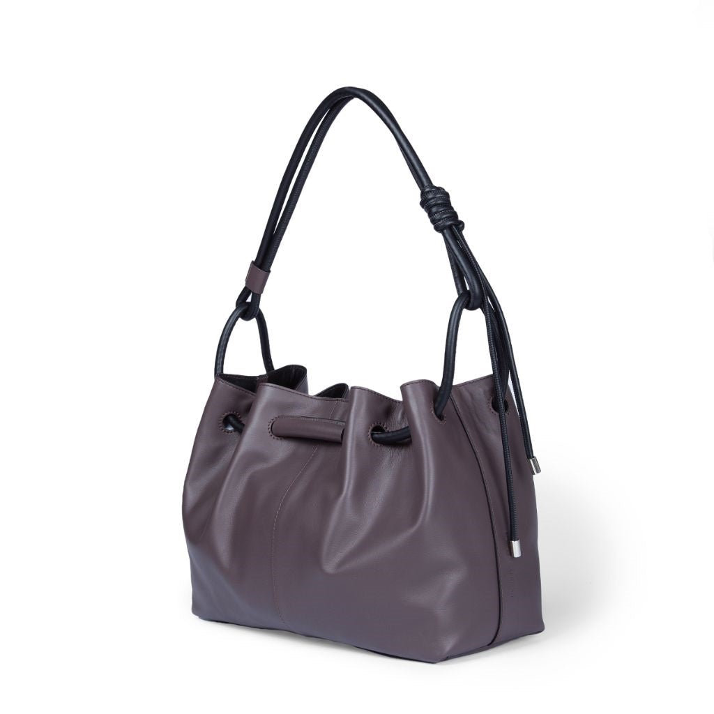 Elegant purple leather handbag with black straps and silver accents