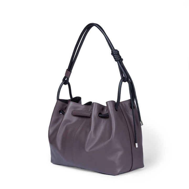 Elegant purple leather handbag with black straps and silver accents