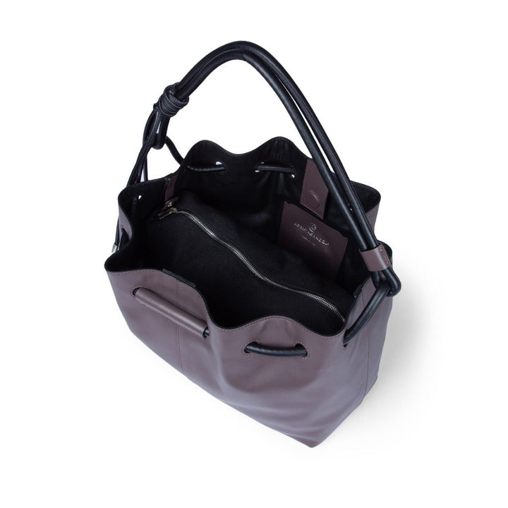 Purple leather bucket bag with black handles, open to reveal interior compartments and a zippered pocket