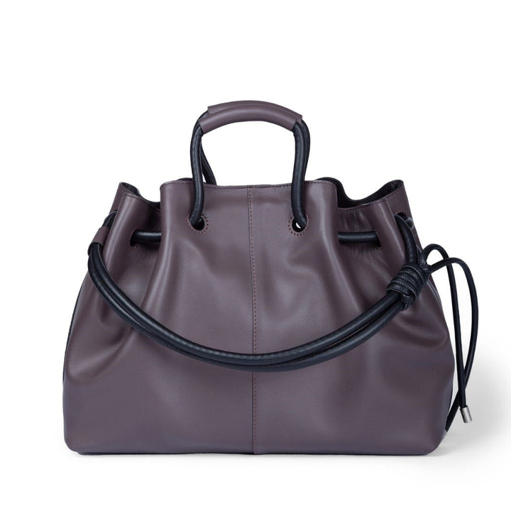 Elegant purple leather handbag with black handles and drawstring detail