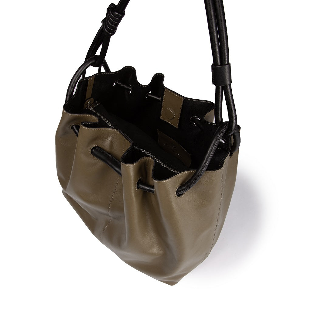 Olive green leather bucket bag with black drawstring detail and black handles