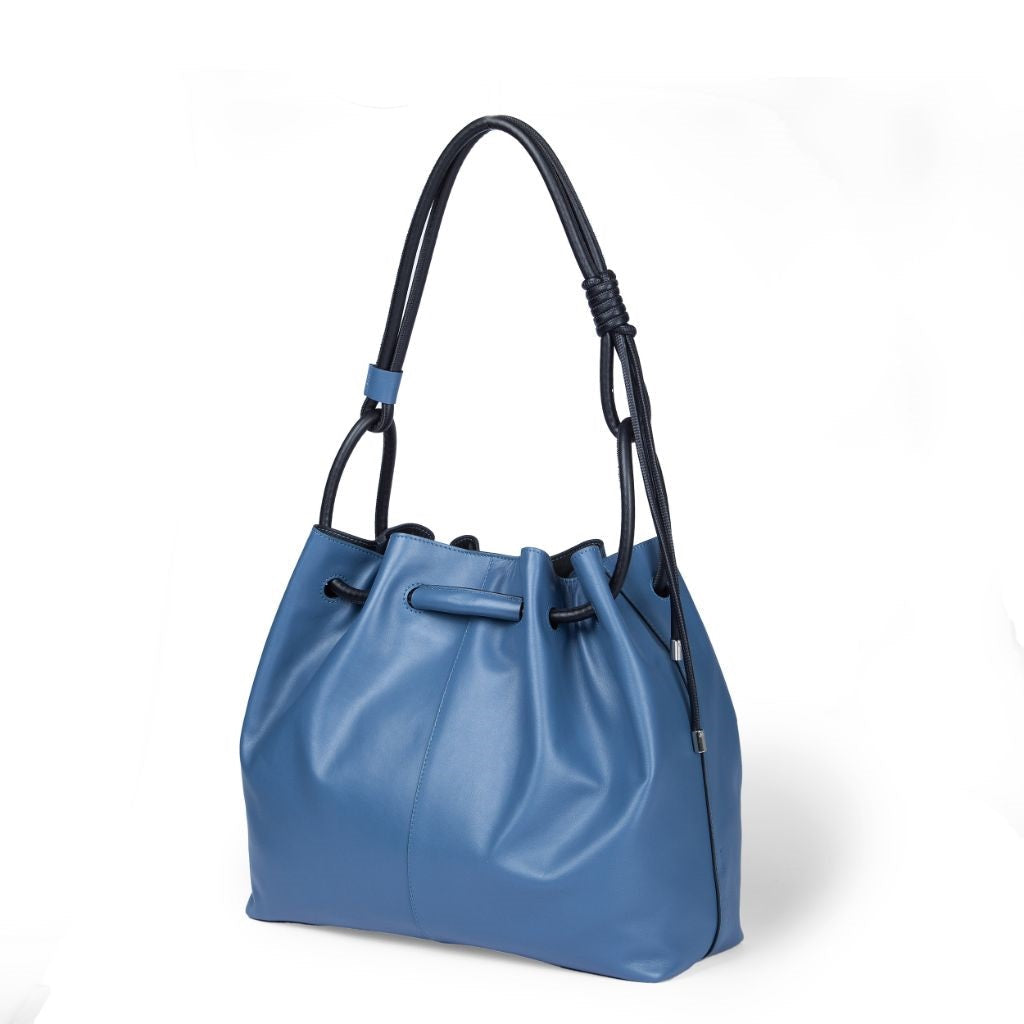 Blue leather drawstring handbag with black shoulder straps on a white background