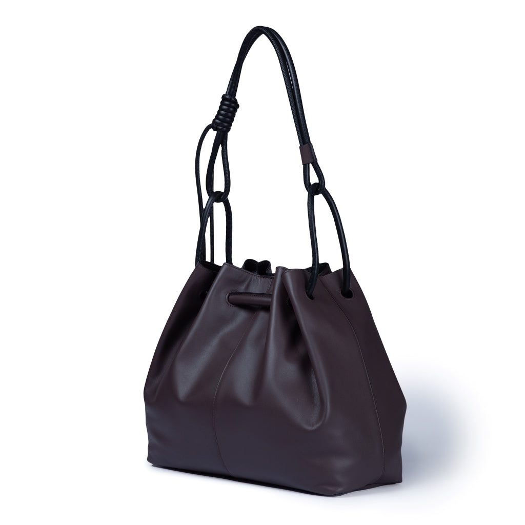 Dark brown leather handbag with black handles on white background