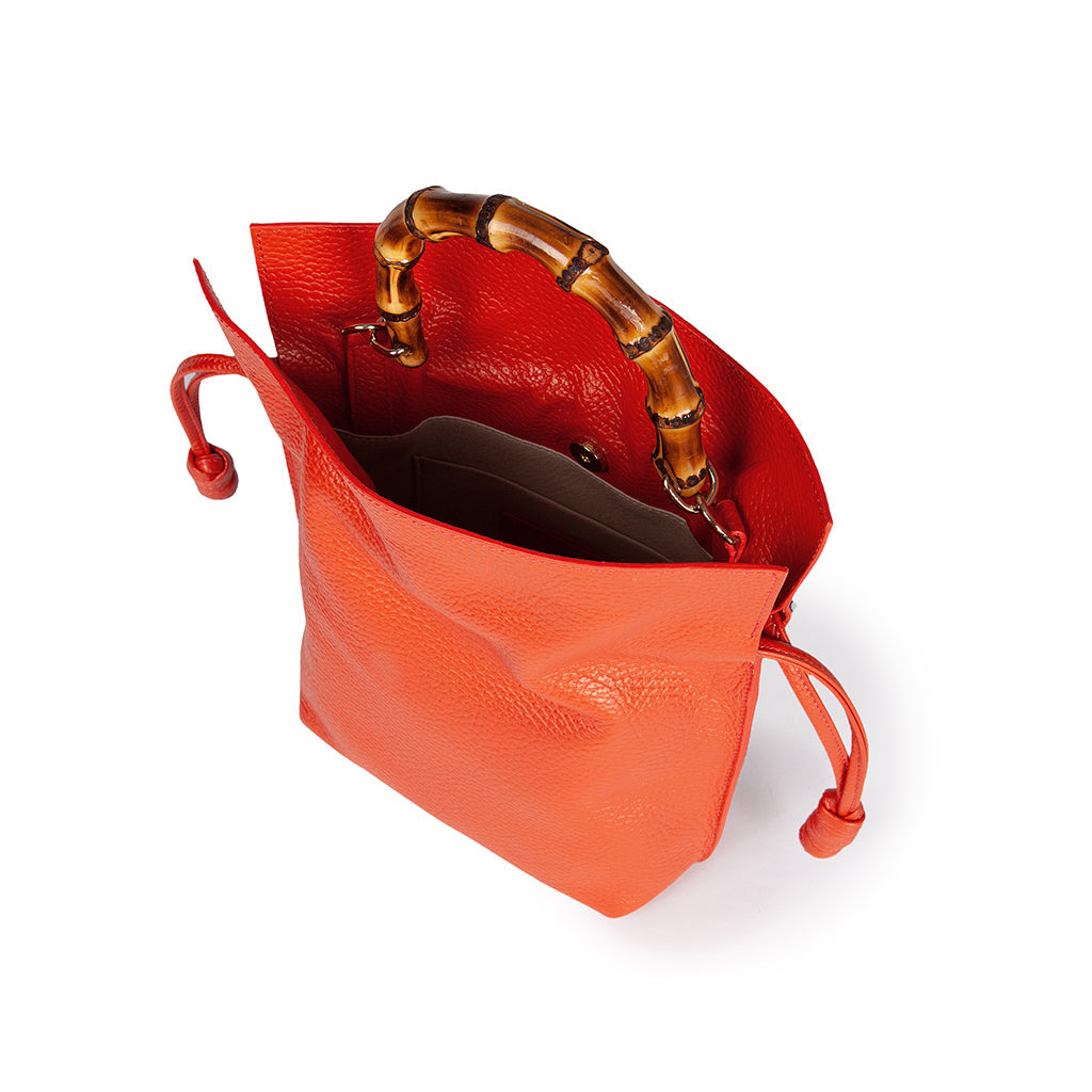 Orange leather handbag with bamboo handle and open top view