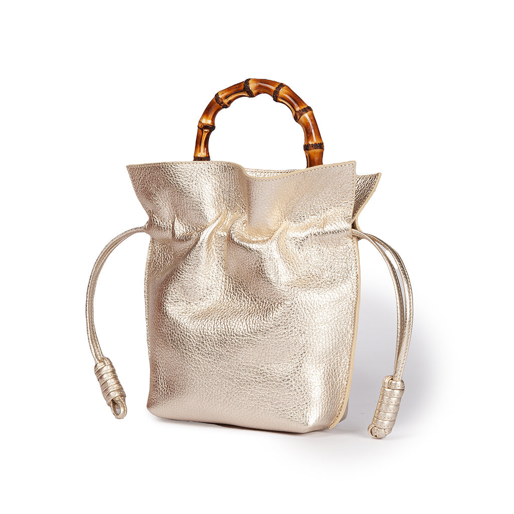 Metallic gold handbag with bamboo handles and drawstring closure