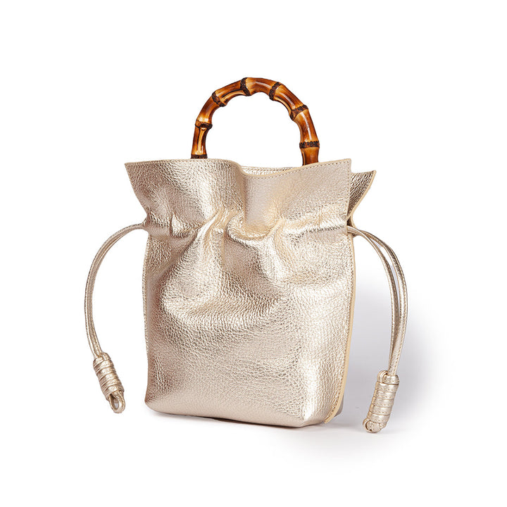 Metallic gold handbag with bamboo handles and drawstring closure