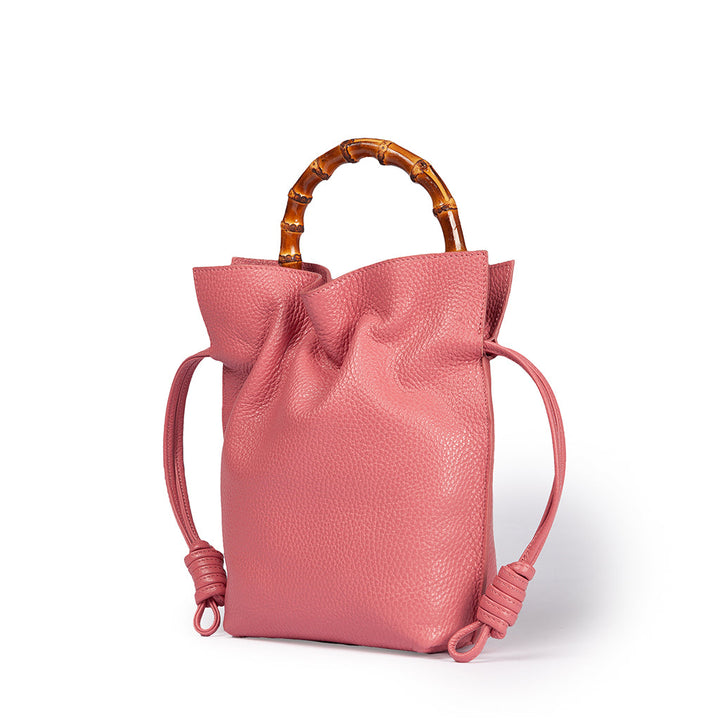 Pink leather handbag with bamboo handle and tie-side details