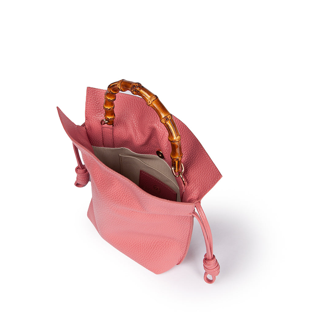 Pink leather handbag with bamboo handle and drawstring closure