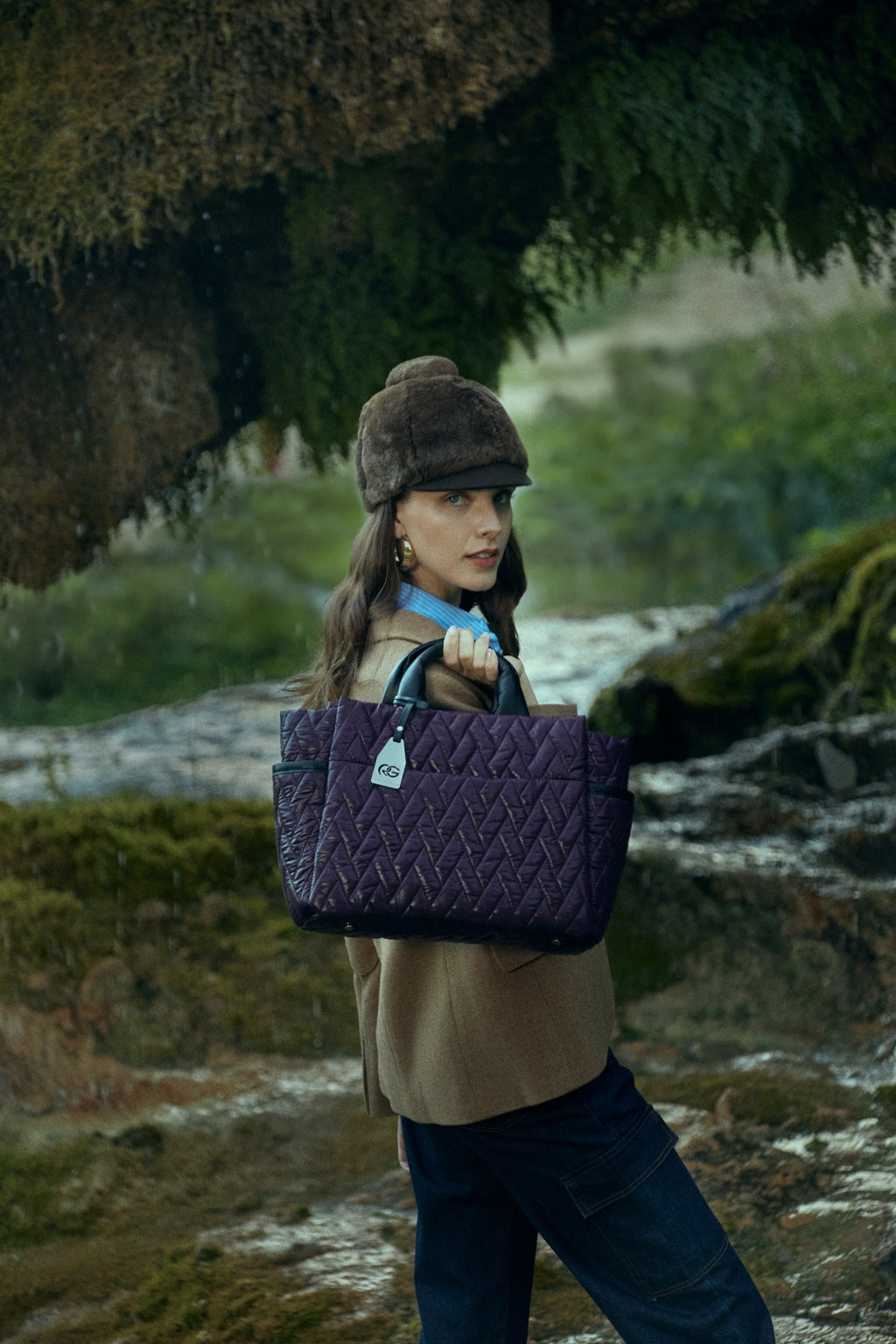 Woman with a purple quilted handbag standing in a nature setting