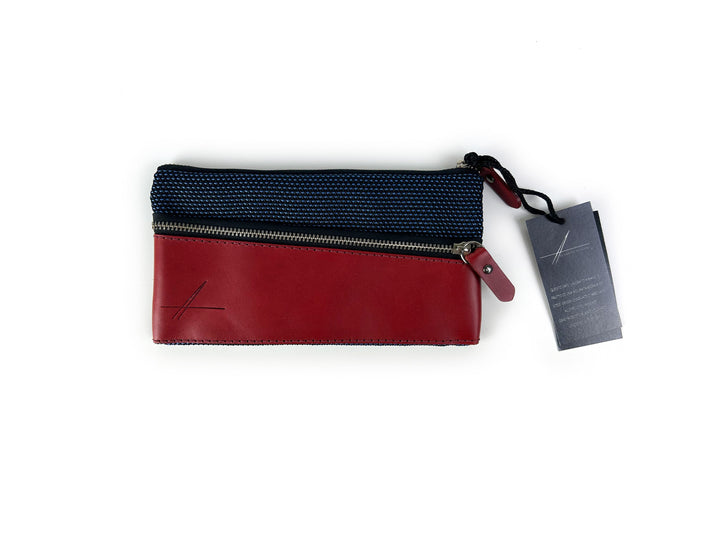 Red and black zippered pouch with attached tag against white background