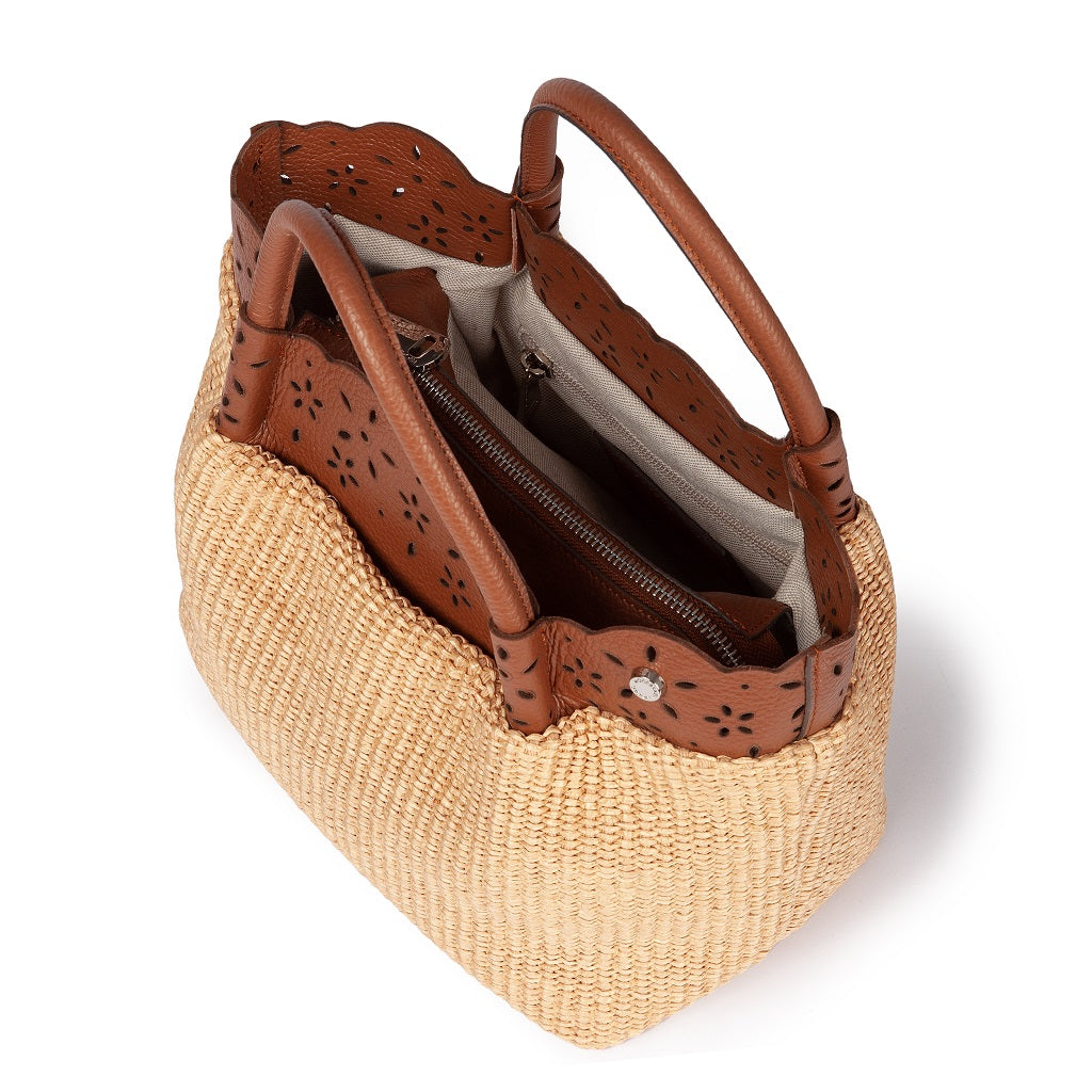 Woven straw tote bag with brown leather handles and perforated detailing