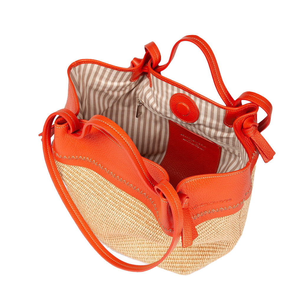 Orange leather and straw handbag with striped interior and magnetic closure